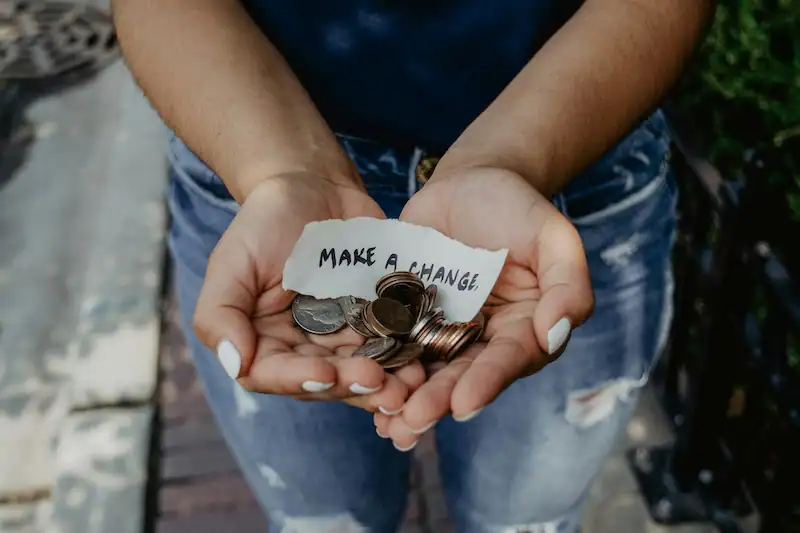 mujer sujeta monedas y habla de hacer un cambio en como usamos el dinero quiere decir la inflación