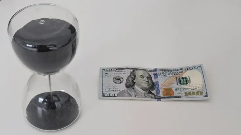 dinero y reljo en la mesa, 100 dolares