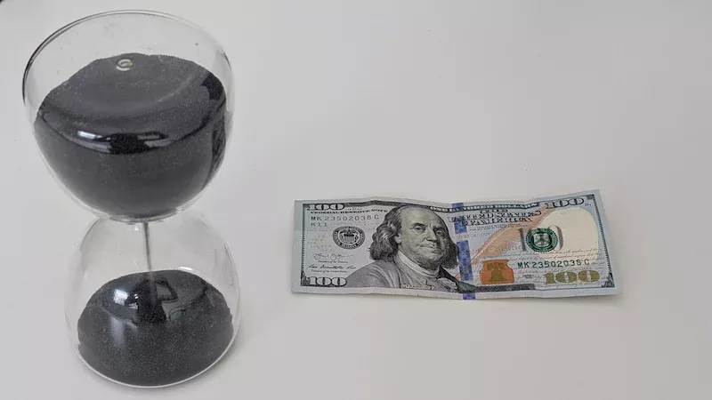 dinero y reljo en la mesa, 100 dolares