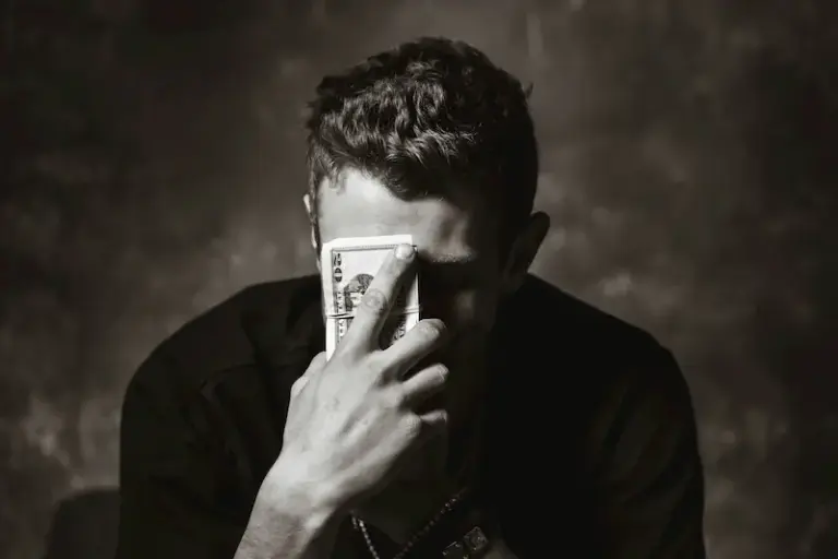 hombre con dinero en frente a la cara probleas y mitos sobre el dinero